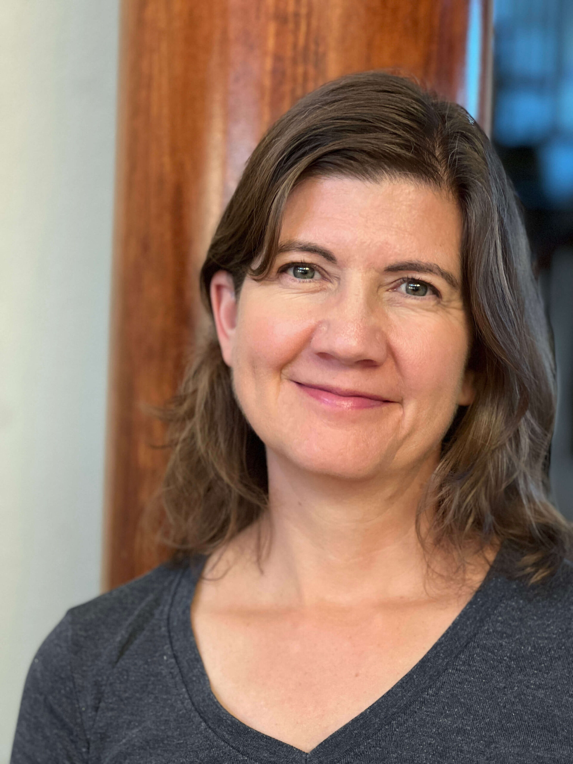 A smiling middle aged woman with brown hair